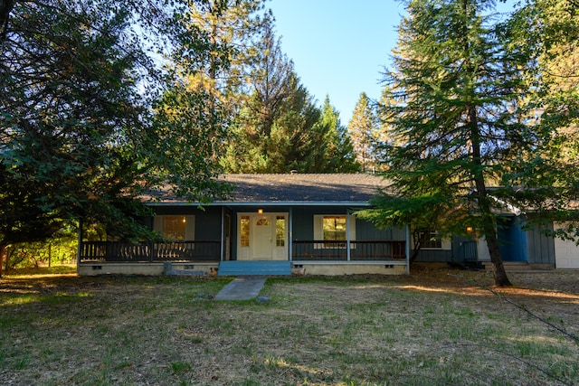 view of front of home with covered porch, a front yard, and a garage