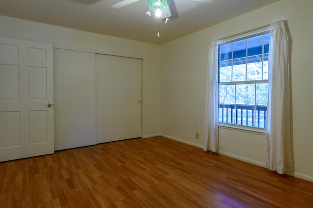 unfurnished bedroom with wood-type flooring, a closet, and ceiling fan