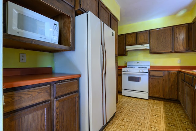 kitchen with dark brown cabinets and white appliances