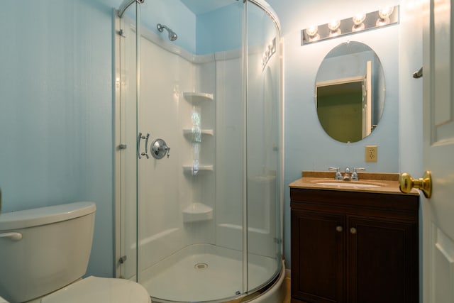 bathroom featuring toilet, a shower with shower door, and vanity