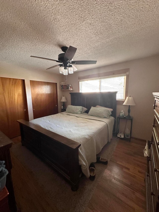 bedroom featuring a textured ceiling, dark wood-type flooring, and ceiling fan