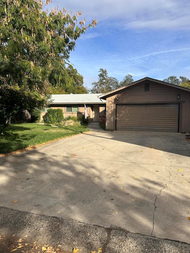 single story home with a garage and a front lawn