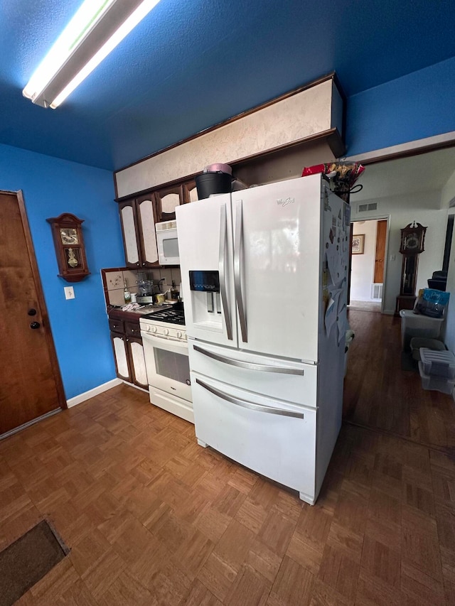 kitchen with white appliances and dark parquet floors