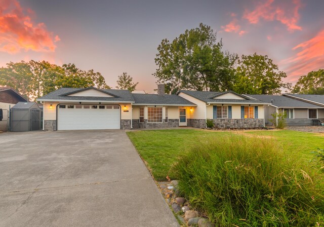 3182 Island Dr, Redding, CA 96001 - single story home with stone siding, a chimney, driveway, a garage, and a lawn