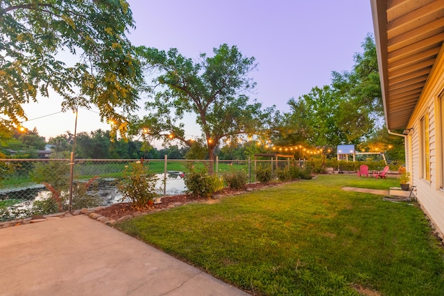 yard at dusk featuring a patio