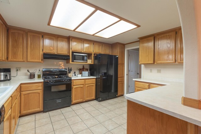 3182 Island Dr, Redding, CA 96001 - kitchen with black appliances, under cabinet range hood, light tile patterned floors, and light countertops