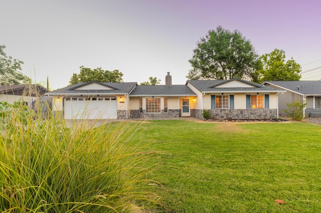 ranch-style home featuring a yard and a garage