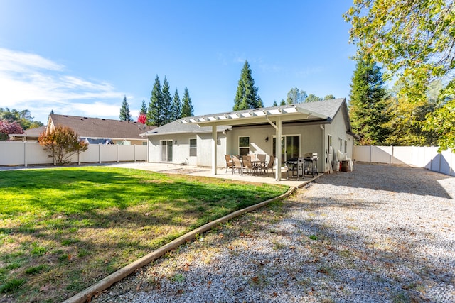 rear view of property featuring a yard and a patio area