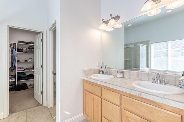 bathroom with walk in shower, vanity, and tile patterned floors