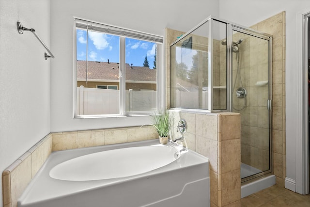 bathroom featuring a bath, tile patterned flooring, and a stall shower