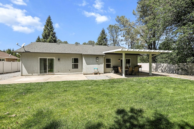 back of house featuring fence, a lawn, a shingled roof, a patio, and stucco siding
