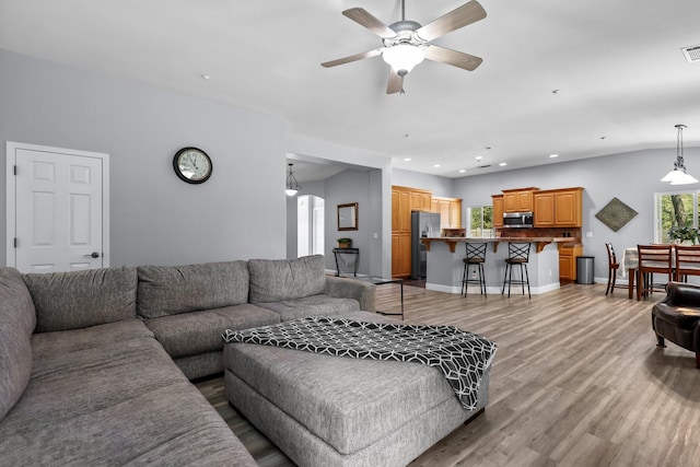 living room with recessed lighting, light wood-style flooring, baseboards, and ceiling fan