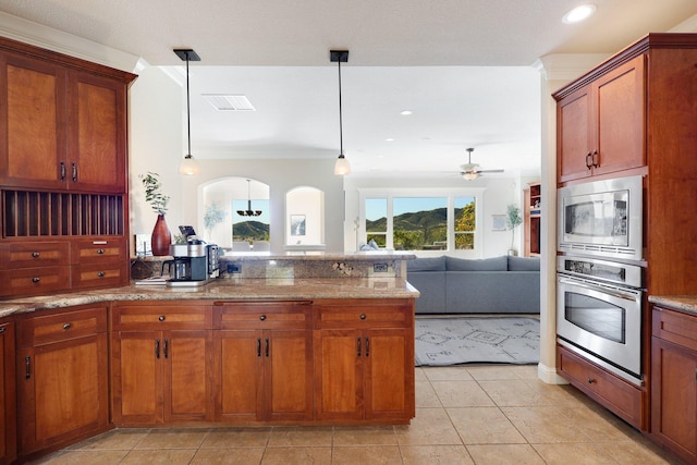 kitchen with hanging light fixtures, ceiling fan, light tile patterned floors, ornamental molding, and stainless steel appliances