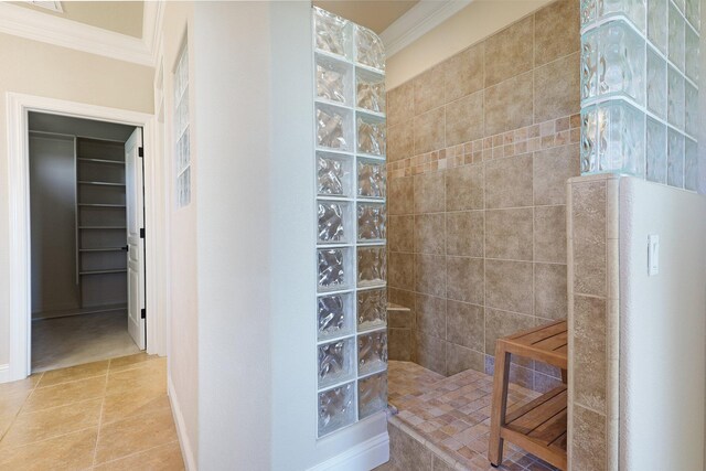 bathroom with tile patterned floors, crown molding, and tiled shower