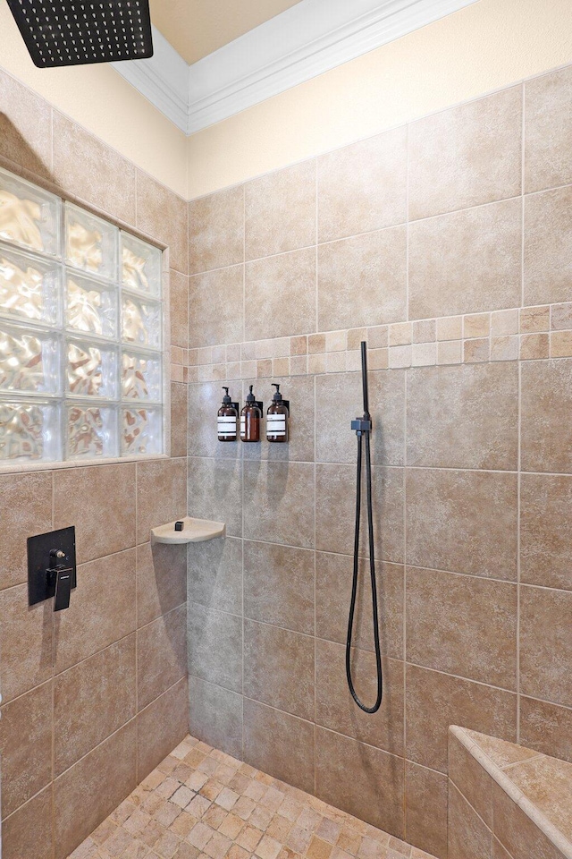 bathroom featuring a tile shower and ornamental molding