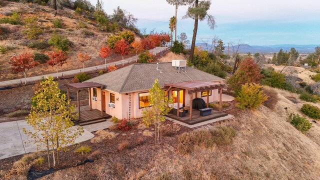 back of property with a pergola and a deck