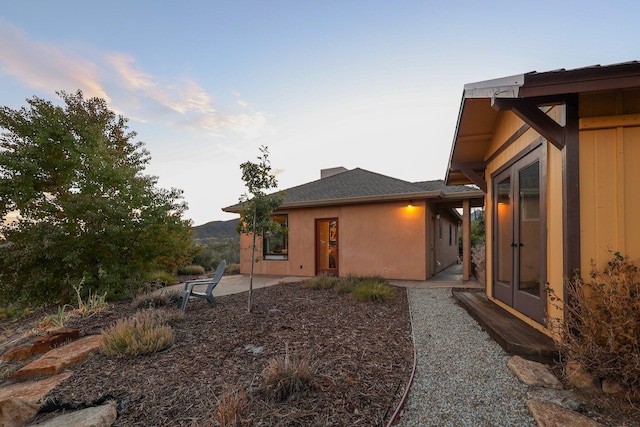 property exterior at dusk featuring a patio