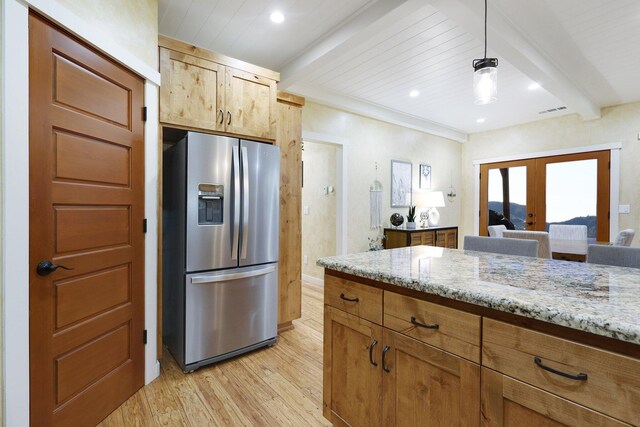 kitchen featuring hanging light fixtures, stainless steel fridge with ice dispenser, light stone counters, beamed ceiling, and light wood-type flooring