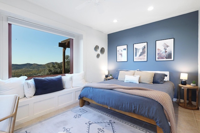 tiled bedroom with multiple windows, a mountain view, and ceiling fan