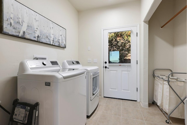 washroom featuring light tile patterned floors and washer and clothes dryer