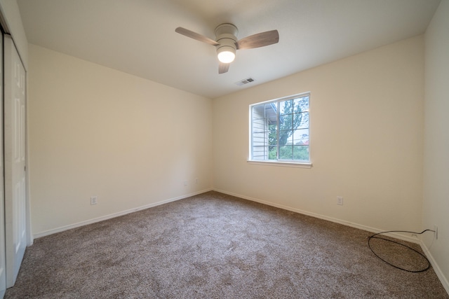 empty room with ceiling fan and carpet floors