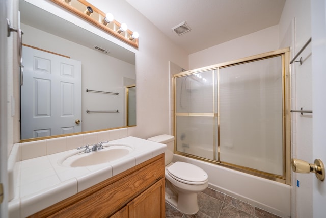 full bathroom featuring vanity, enclosed tub / shower combo, and toilet