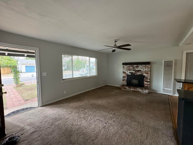 unfurnished living room featuring a wealth of natural light, ceiling fan, and carpet floors