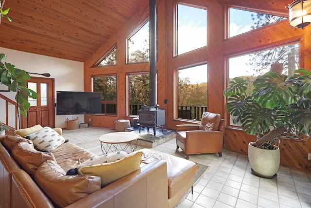 sunroom / solarium with lofted ceiling, a wood stove, and wood ceiling