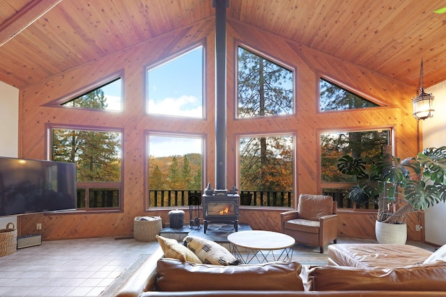 living room featuring a wood stove, plenty of natural light, high vaulted ceiling, and wood ceiling