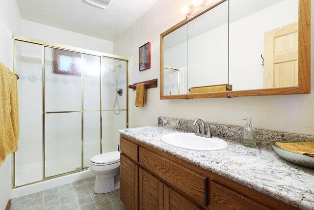 bathroom with vanity, an enclosed shower, and toilet