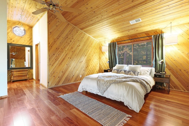 bedroom with vaulted ceiling, ceiling fan, wood-type flooring, wooden ceiling, and wood walls