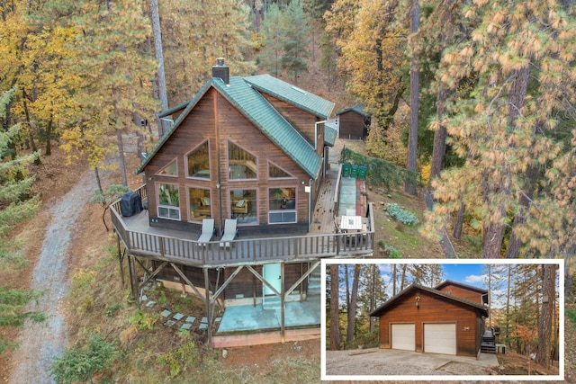 back of property featuring a wooden deck, an outdoor structure, and a garage