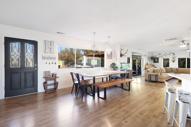 dining space with ceiling fan and wood-type flooring