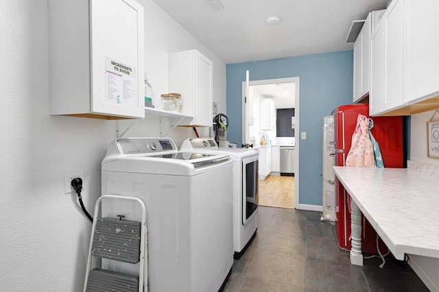 clothes washing area with cabinets and washer and dryer