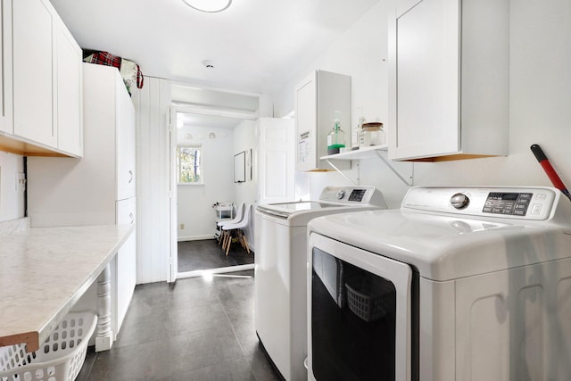 washroom featuring washing machine and dryer and cabinets