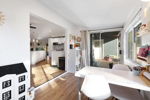 dining area with light wood-type flooring and ceiling fan