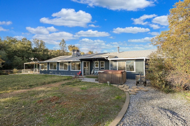 view of front facade featuring a front yard, a hot tub, cooling unit, and a sunroom