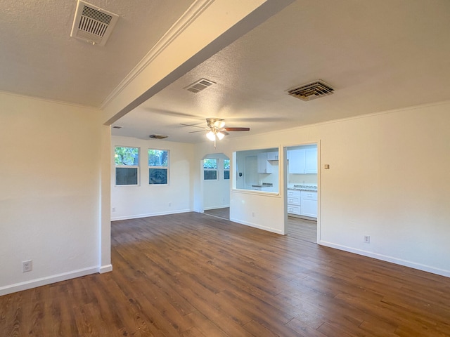 unfurnished living room featuring ornamental molding, ceiling fan, a textured ceiling, and dark hardwood / wood-style floors