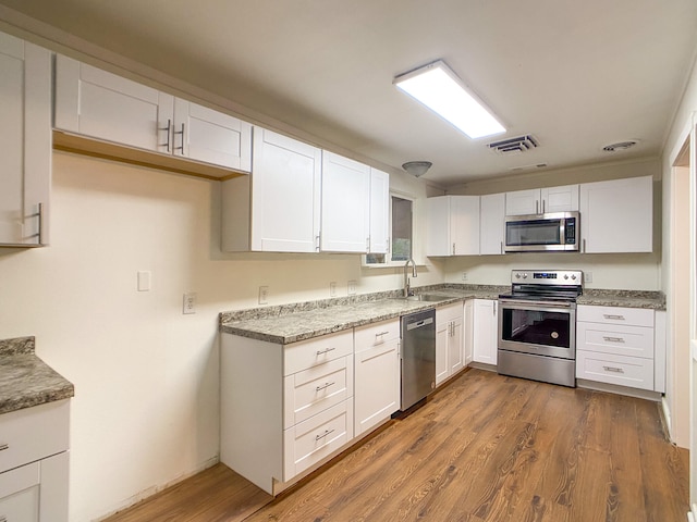 kitchen featuring white cabinetry, sink, dark hardwood / wood-style floors, and stainless steel appliances