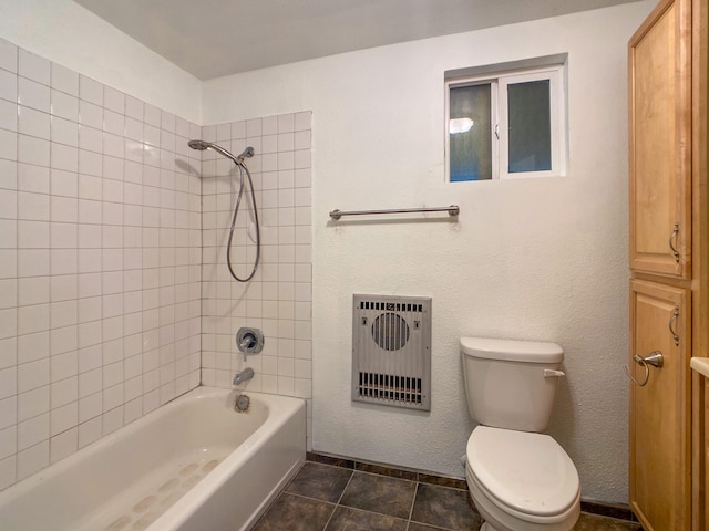 bathroom featuring tile patterned flooring, tiled shower / bath, toilet, and heating unit