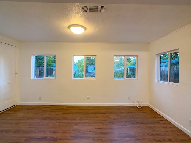 empty room featuring dark wood-type flooring and a textured ceiling