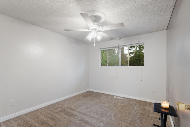 carpeted spare room featuring ceiling fan and a textured ceiling