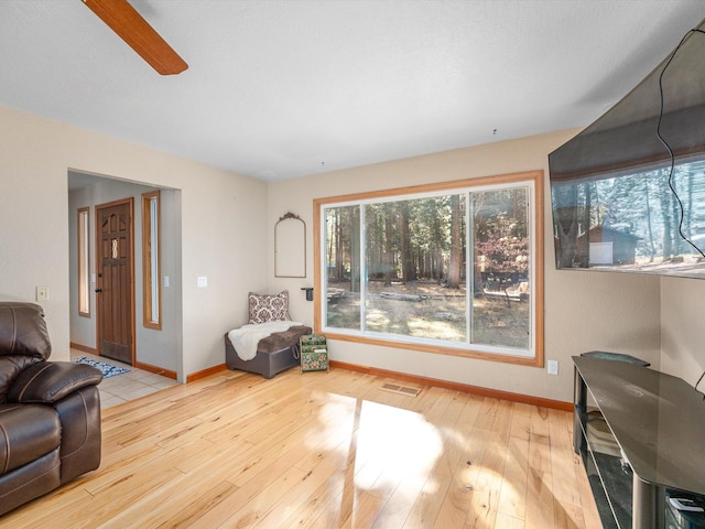 living room with ceiling fan and light wood-type flooring