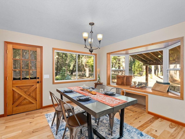 dining area featuring a chandelier, light hardwood / wood-style floors, and plenty of natural light