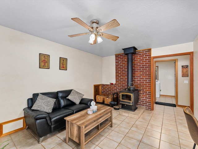 living room featuring ceiling fan, washer / dryer, and light tile patterned flooring