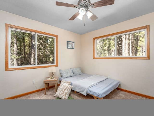 carpeted bedroom with multiple windows and ceiling fan