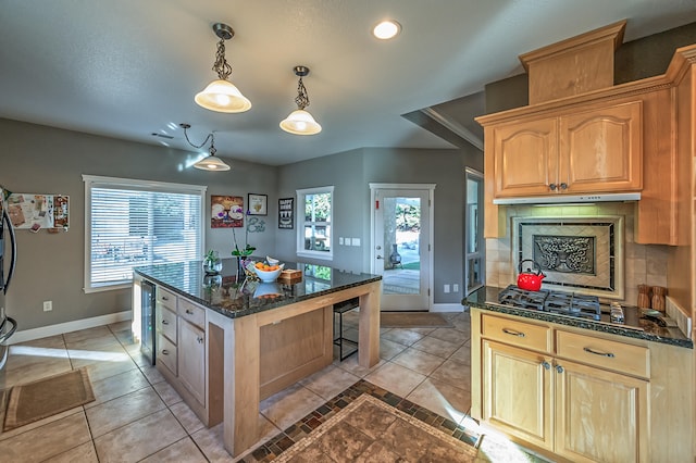 kitchen with decorative backsplash, a wealth of natural light, hanging light fixtures, and stainless steel gas stovetop