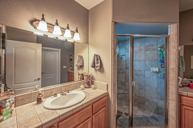 bathroom featuring walk in shower and vanity