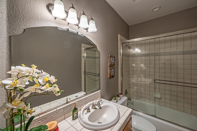 full bathroom with bath / shower combo with glass door, vanity, and toilet