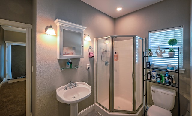 bathroom featuring toilet, an enclosed shower, and sink